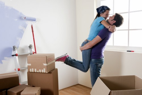 Local movers carrying furniture through a narrow Islington stairwell